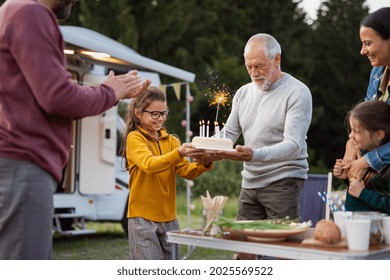 Multi-generation family celebrating birthday outdoors at campsite, caravan holiday trip. - Powered by Shutterstock