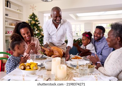 Multi-Generation Family Celebrating Christmas At Home With Grandfather Serving Turkey - Powered by Shutterstock