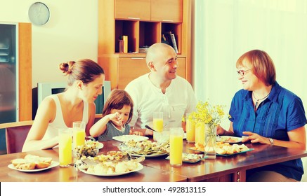  Multigeneration Family  Eating Fish With Vegetables At Home Together