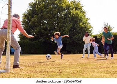 Multi-Generation Family At Home In Garden Playing Football Or Soccer Together - Powered by Shutterstock