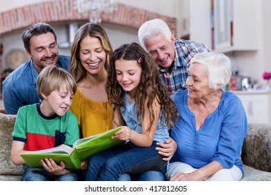 Multi-generation Family Looking At A Photo Album At Home