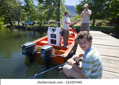 Multi-generation Family On Dock With Fishing Equipment And Boat