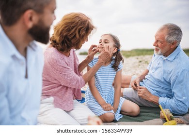 Multigeneration Family On A Holiday By The Lake, Having Picnic.