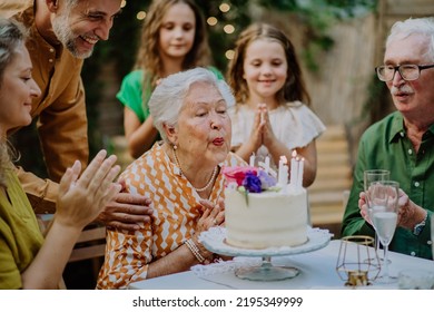 Multi-generation family on outdoor summer garden party, celebrating birthday - Powered by Shutterstock