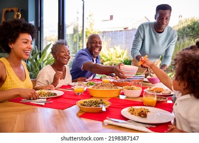 Multi-Generation Family Sitting Around Table At Home Enjoying Meal Together - Powered by Shutterstock