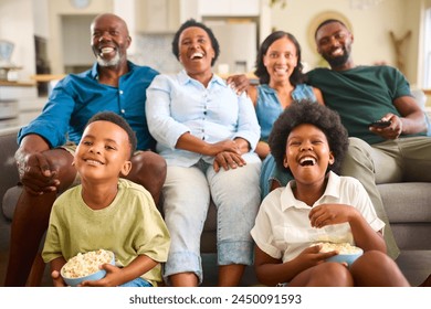 Multi-Generation Family Sitting On Sofa At Home Watching TV Together - Powered by Shutterstock