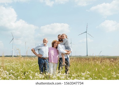 Multigeneration family standing on field on wind farm. - Shutterstock ID 1563347734