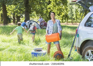 Multi-Generation Family Unpacking Car On Camping Trip