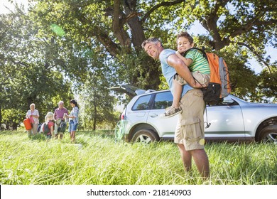 Multi-Generation Family Unpacking Car On Camping Trip