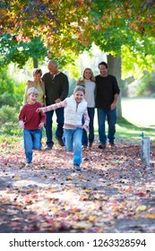 Multi-generation family walking through autumn park