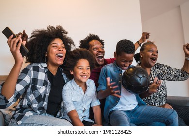 Multi-generation family watching soccer match at home. - Powered by Shutterstock