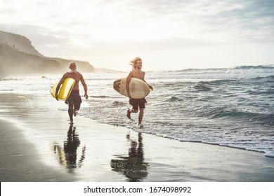 Multigeneration friends going to surf on tropical beach - Family people having fun doing extreme sport - Joyful elderly and healthy lifestyle concept - Main focus on young guy face - Powered by Shutterstock