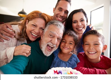 Multi-Generation Hispanic Family Taking Selfie To Celebrate Granddaughters Birthday At Home