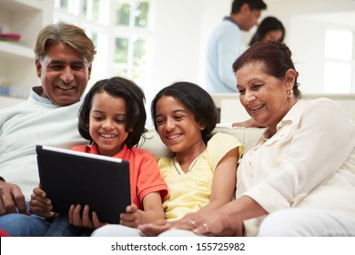 Multi-Generation Indian Family With Digital Tablet