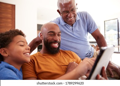 Multi-Generation Male African American Family Sitting On Sofa At Home Using Digital Tablet - Powered by Shutterstock