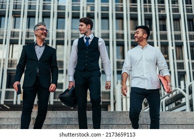 Multigenerational Business People Walking Down The Steps In Front Of Their Company