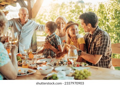 Multigenerational family enjoying a family lunch on a patio at a vineyard - Powered by Shutterstock