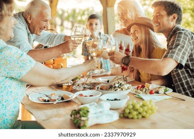 Multigenerational family enjoying a family lunch on a patio at a vineyard - Powered by Shutterstock