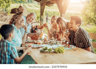 Multigenerational family enjoying a family lunch on a patio at a vineyard - Powered by Shutterstock