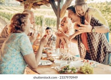 Multigenerational family enjoying a family lunch on a patio at a vineyard - Powered by Shutterstock