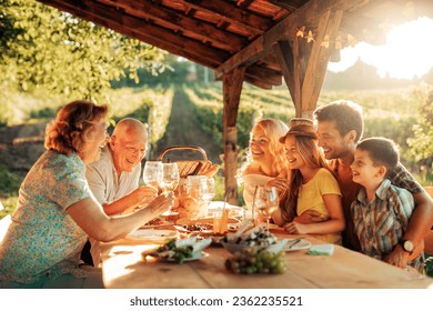 Multigenerational family enjoying a lunch on the balcony of a house in a vineyard in the countryside - Powered by Shutterstock