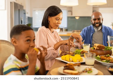 multigenerational family enjoying meal together, eating corn and salad at dining table. mealtime, bonding, togetherness, healthy, vegetables - Powered by Shutterstock