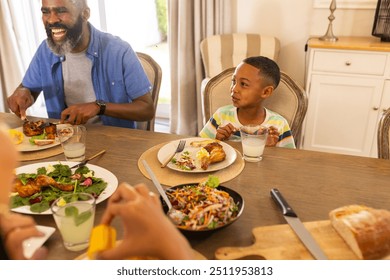 multigenerational family enjoying meal together at dining table, smiling and sharing food. happiness, togetherness, bonding, celebration - Powered by Shutterstock