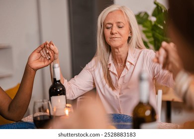 Multigenerational family gathers for a festive christmas dinner. Holding hands in prayer before the meal. Expressing gratitude and faith in their cozy home filled with love. Togetherness - Powered by Shutterstock