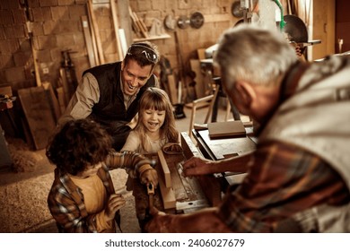 Multigenerational family having fun in woodshop