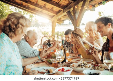 Multigenerational family having lunch in a gazebo on the vineyard - Powered by Shutterstock