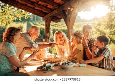 Multigenerational family having a family lunch outdoors on a patio - Powered by Shutterstock