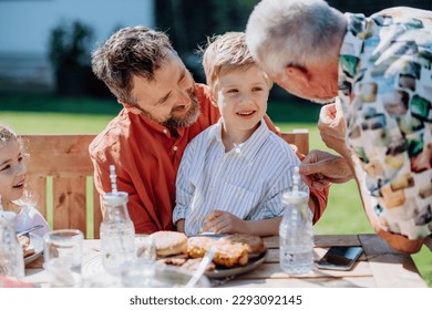 Multigenerational family having outdoor barbecue party in the backyard. - Powered by Shutterstock