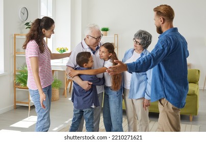 Multigenerational family meet together. Large friendly family meets together on weekends to spend bonding times at home. Young parents, grandparents and grandchildren are hugging together in room. - Powered by Shutterstock