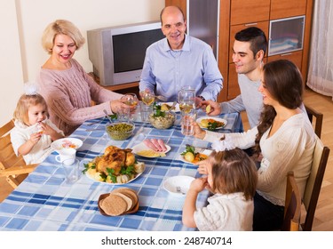 Multigenerational Family Sitting At The Table Set For Dinner And Talks