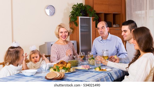 Multigenerational Family Sitting At The Table Set For Dinner