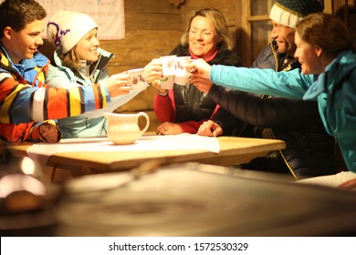 Multigenerational Family Sitting Together In Ski Resort Cabin