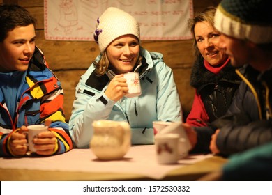 Multigenerational Family Sitting Together In Ski Resort Cabin