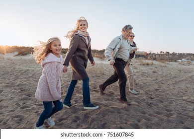 Multigenerational Family Spending Time Together And Walking On Beach