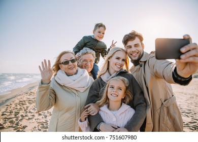 multigenerational family taking selfie on smartphone at seaside - Shutterstock ID 751607980