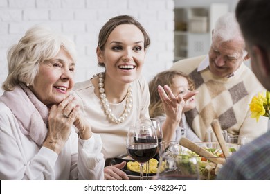 Multi-generational family talking and enjoying dinner together