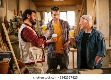 Multigenerational group of carpenters having a coffee break at the carpenters shop - Powered by Shutterstock