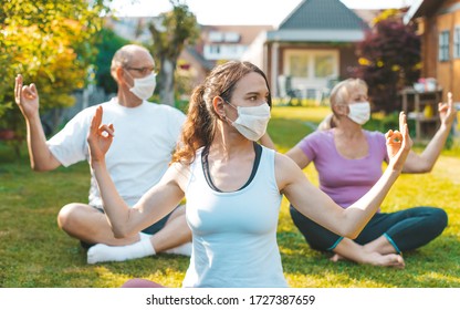 Multigenerational Group Of People Making Yoga Exercises Outdoors Wearing Medical Protective Masks - Concept Of Life During Or After Quarantine, Coronavirus Protection Measures