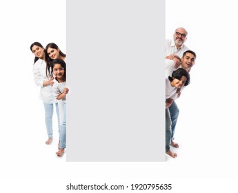 Multigenerational Indian asian family with white board, pointing or presenting empty white placard - Powered by Shutterstock