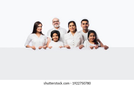 Multigenerational Indian Asian Family With White Board, Pointing Or Presenting Empty White Placard