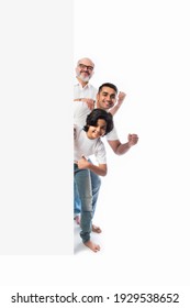 Multigenerational Indian Asian Family With White Board, Pointing Or Presenting Empty White Placard