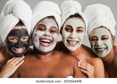 Multigenerational women having fun wearing face beauty masks for skin care therapy - Main focus on african girl face