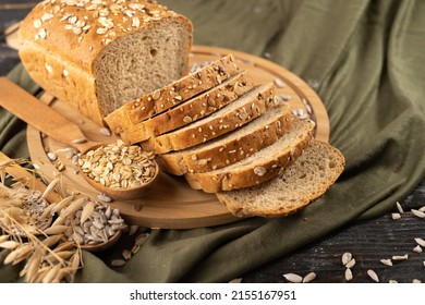 Multigrain bread on a wooden board with ears of rye and oats on a rustic cloth in the background, homemade baking concept - Powered by Shutterstock