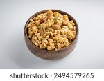 Multigrain granola with a mixture of nuts in wooden bowl on a white background. Tasty and healthy breakfast. Food made of granola and musli.