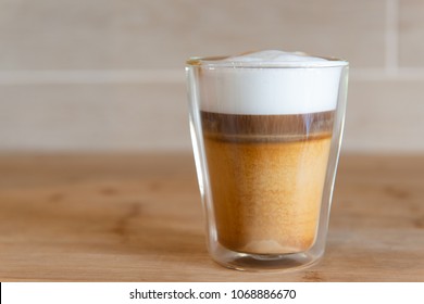 Multilayer Coffee Or Cappuccino In A Glass Cup On Wooden Table