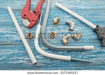 Multilayer pipe with accessories and fittings over a blue vintage wooden background